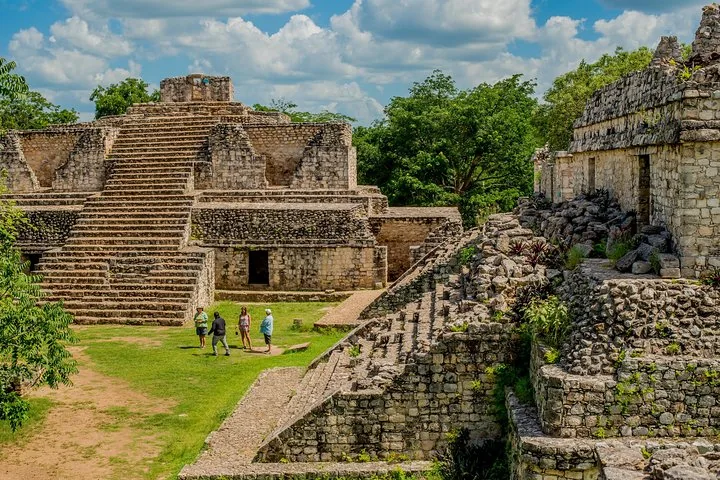 Touristen erkunden die Steinpyramiden der Maya-Ruinen von Ek Balam
